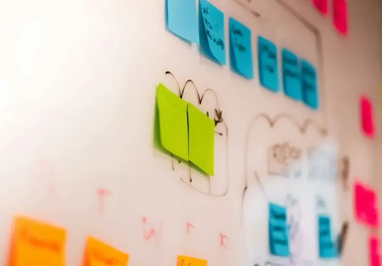 Colored sticky notes arranged on a whiteboard during a planning session