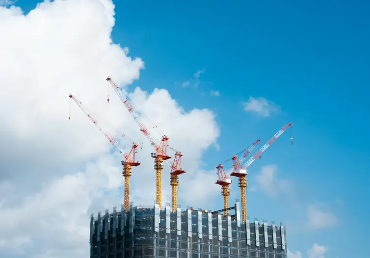 Tower cranes above a high-rise building under construction