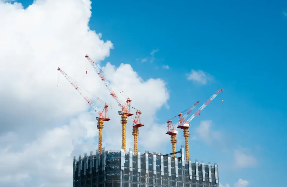 Tower cranes above a high-rise building under construction
