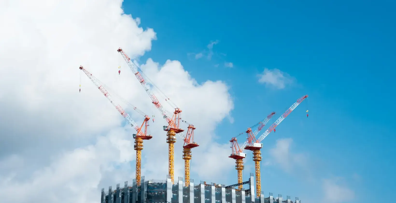 Tower cranes above a high-rise building under construction