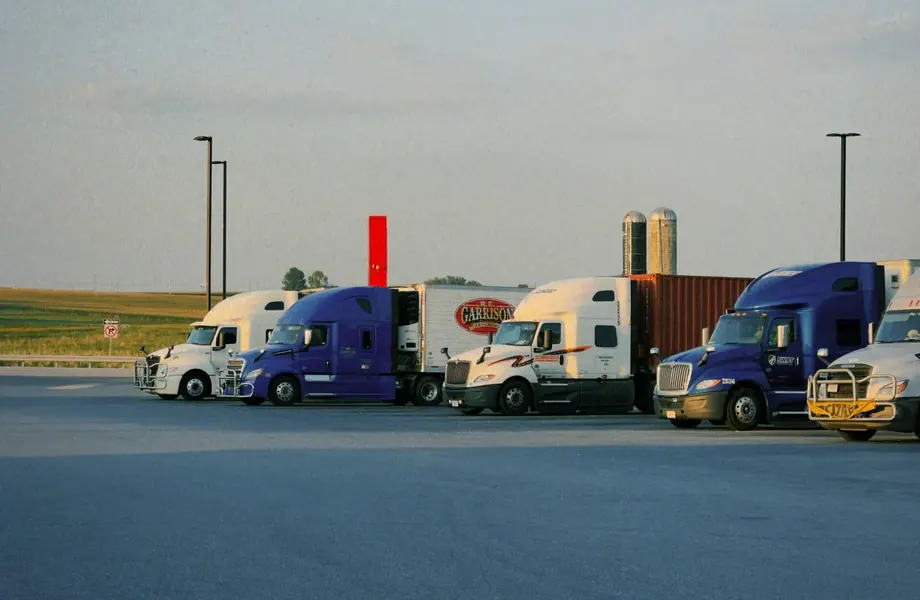 Row of parked semi-trucks at a freight yard