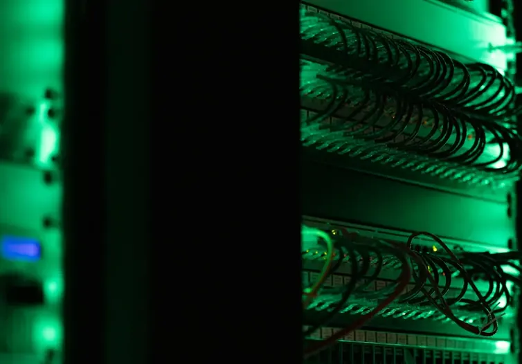 Server rack with network cables lit in green