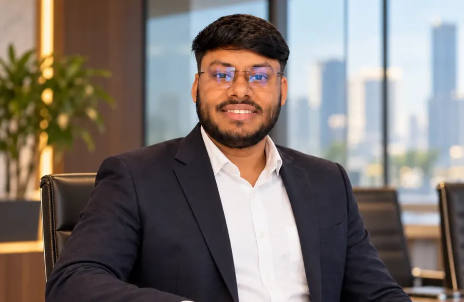 Vikas Saroj seated at a meeting table with a laptop and notebook
