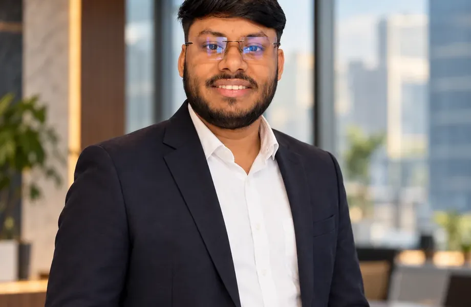 Vikas Saroj standing in an office holding a laptop